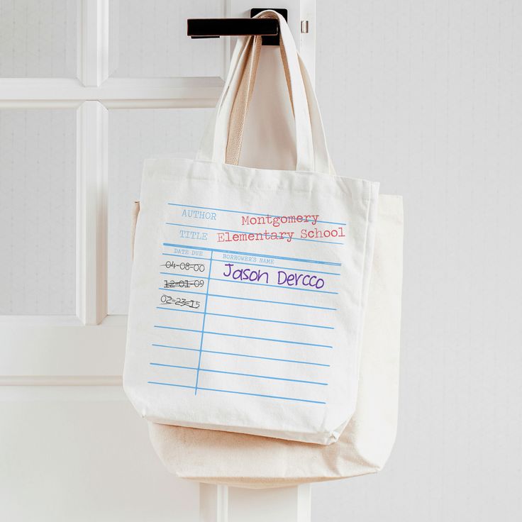 a tote bag hanging on a hook in front of a door with writing on it