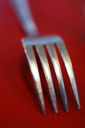 a fork is sitting on a red surface