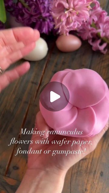 a person holding a fake flower in their hand with the words making beautiful flowers with water paper, fondant or gumpaste