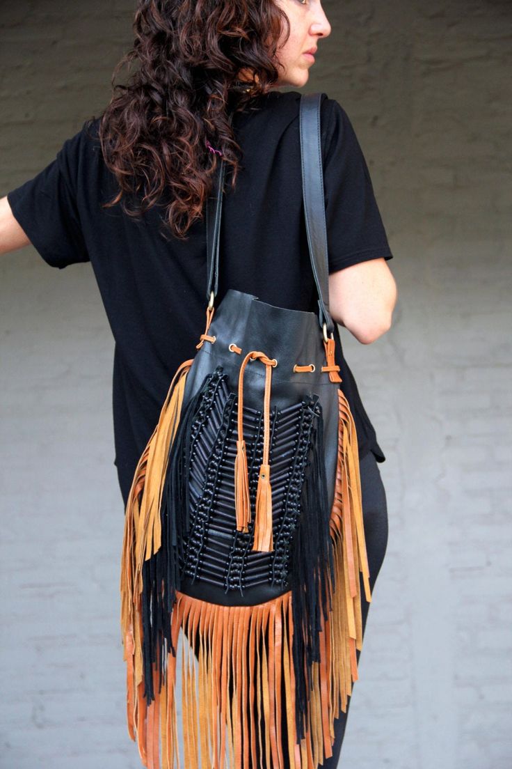 Boho style fringed leather bag black with tan fringes and black bone choker Bone bead choker attached as decoration Fully lined inside with one pocket. strap can be adjusted to several lengths. Material: leather, cow bones 26 cm wide,39 cm long. total long include leather fringes 60 cm Best finishing quality Please note that our products are handmade with some natural materials. For this reason the used materials such as leather and feathers may have slight variations in color. Please do not for Black Bohemian Shoulder Bag With Tassels, Black Bohemian Bag With Fringe, Handmade Black Leather Bucket Bag, Handmade Black Bucket Bag, Black Travel Shoulder Bag With Tassels, Bohemian Shoulder Bag With Tassels For Fall, Black Fringed Shoulder Bag For Festival, Black Bohemian Hobo Bag, Black Fringe Shoulder Bag For Festival