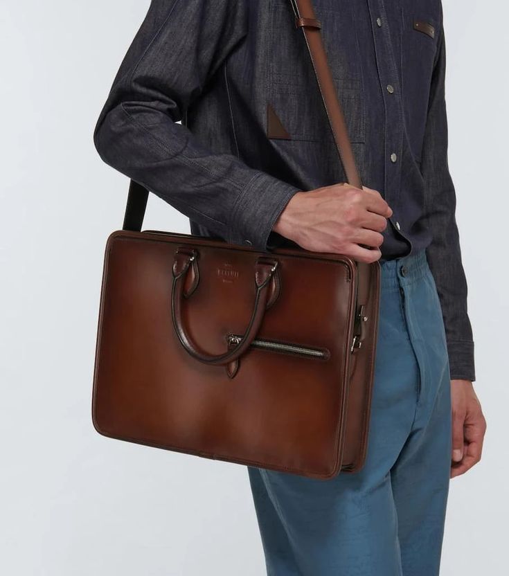 This Berluti briefcase is made in Italy from brown leather. It features two top handles, a detachable shoulder strap, and a subtle embossed logo..Closure: two-way zipped top.Color of fastening: antique silver.Internal details: fabric lining, internal slot pockets, internal zipped pocket.Material: leather.zipped front pocket.Made in Italy.detachable, adjustable shoulder strap, top handles.Height 27cm-10.5'.Width 38cm-15'.Depth 6cm-2.5'.Length of handles 35cm-14'.Min. length shoulder strap 124cm-4 Business Satchel Briefcase With Detachable Handle, Business Leather Shoulder Bag With Detachable Handle, Cognac Leather Laptop Bag For Work, Cognac Leather Satchel For Business, Luxury Cognac Briefcase With Leather Handles, Business Briefcase With Detachable Handle In Tote Shape, Business Briefcase With Detachable Handle And Tote Shape, Cognac Leather Lined Laptop Bag For Work, Cognac Leather-lined Laptop Bag For Business