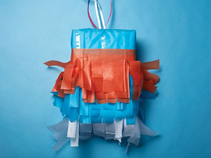 an ornament made out of orange and blue tissue paper on a blue background