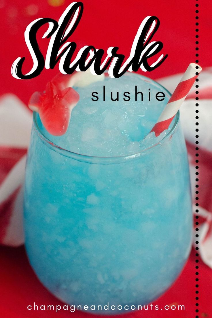 a blue drink in a glass with the words shark slushie on it and candy cane