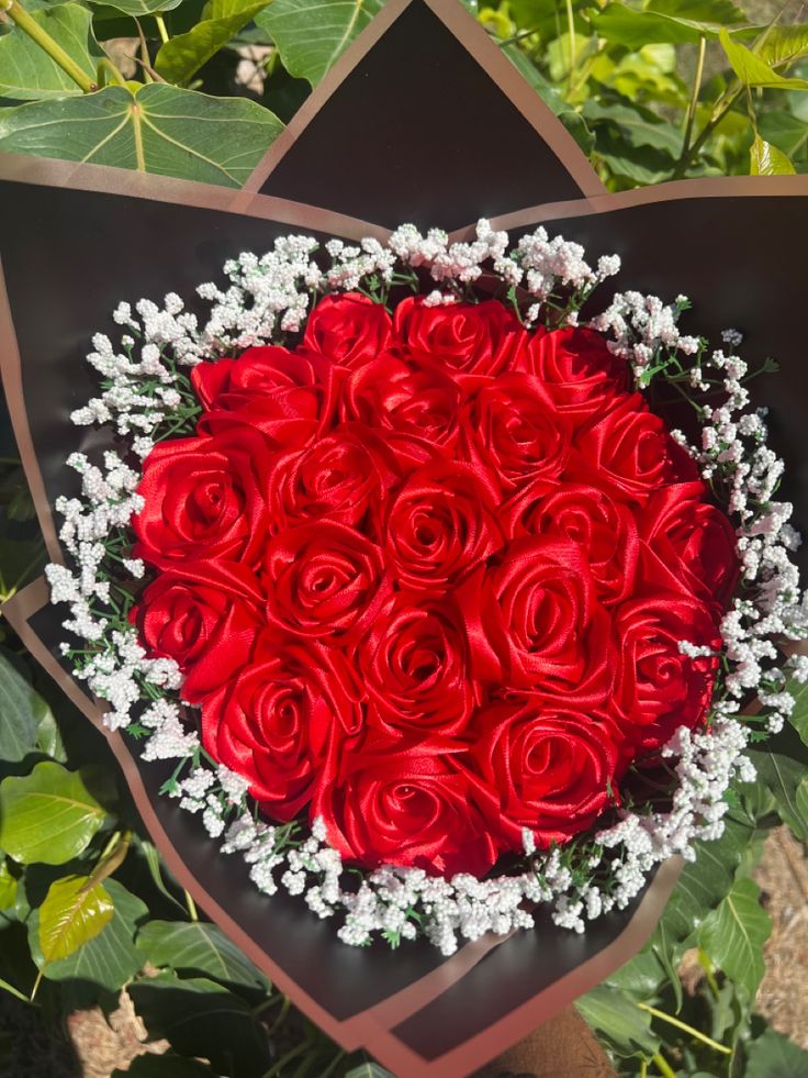 a bouquet of red roses in the shape of a heart