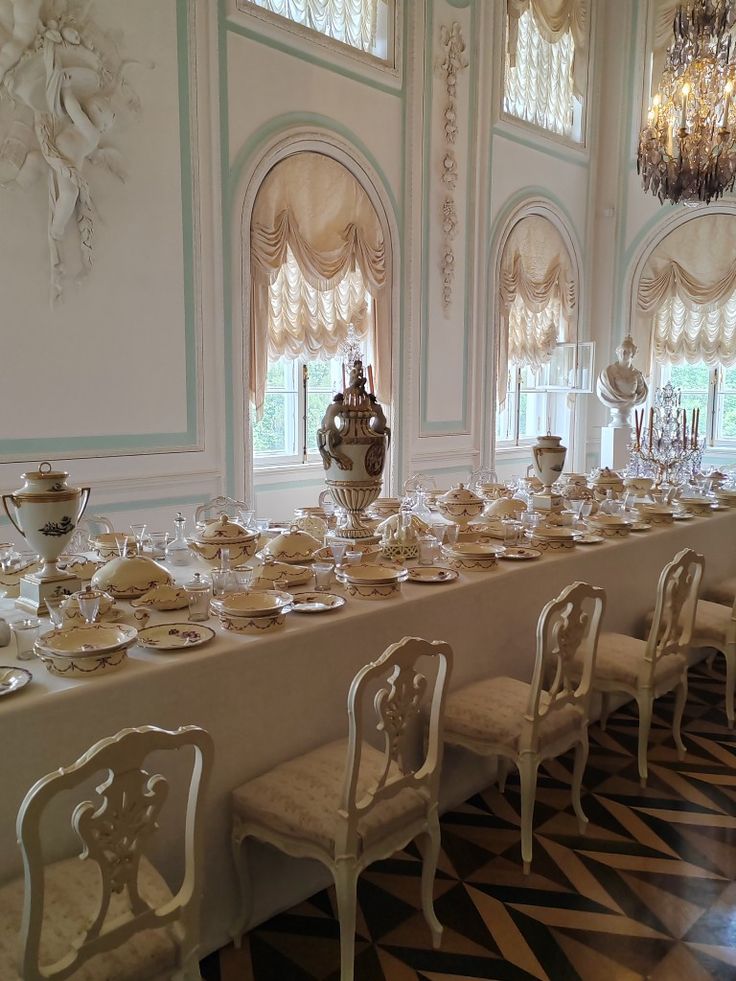 a long table is set up with plates and silverware for formal dinnereons