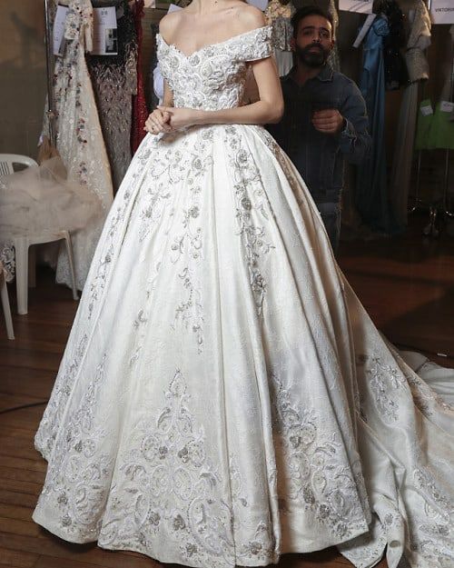 a woman in a white wedding dress standing next to a mannequin