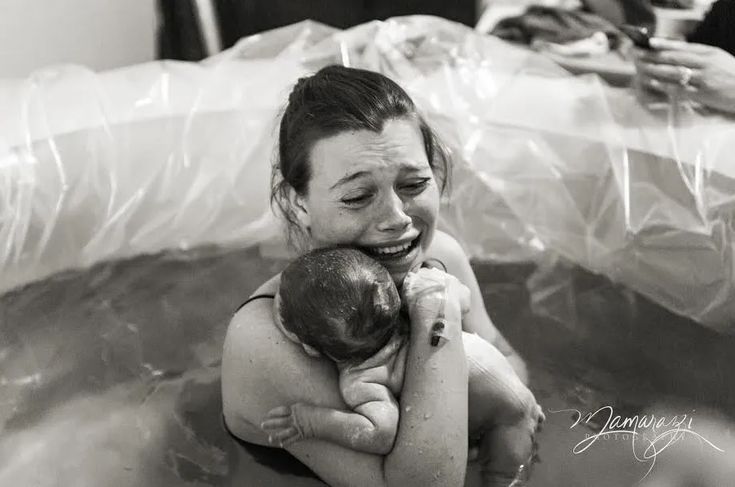 a woman holding a baby in a bathtub