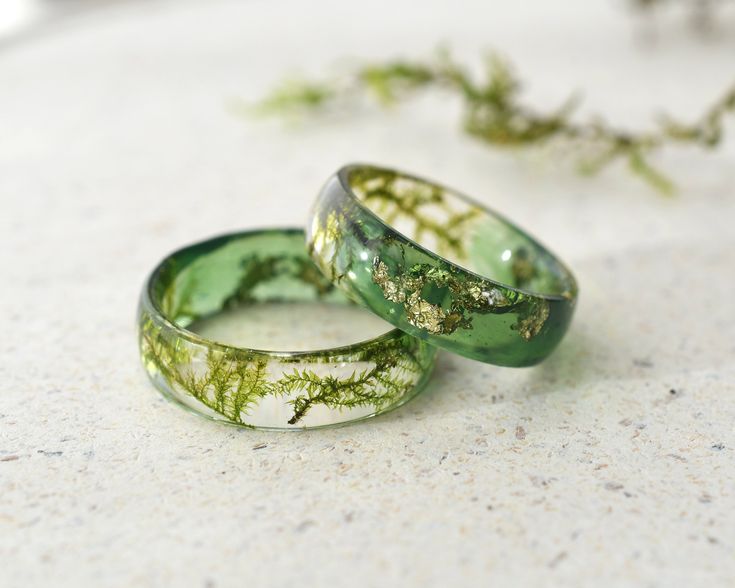 two wedding rings with moss growing on them