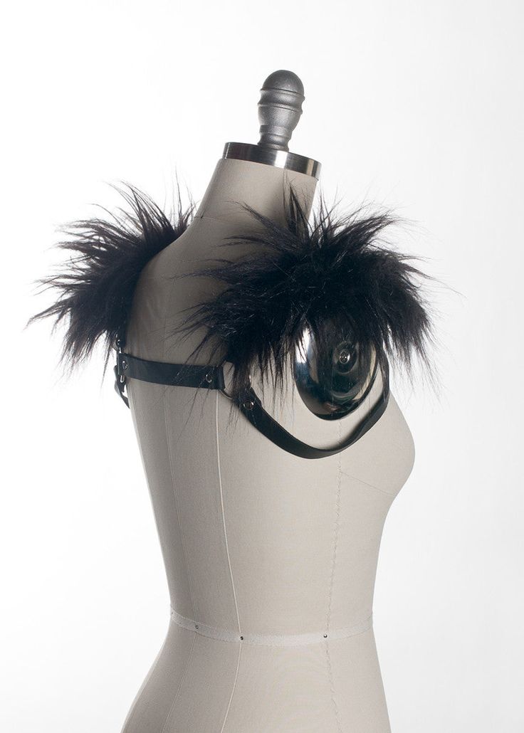 This chest harness with faux fur shoulder detail adds instant gothic drama and impact to any outfit. This piece works especially well with dresses and flowing tops that don't have a defined waistline, or paired with a corset. Buckles in front across chest. Silver toned nickel-plated steel hardware. Shown in black leather. Also available in PVC. All colors have black faux fur except white PVC, which has white faux fur.All pieces are MADE TO ORDER, standard sizes XS-4XL. If your measurements fall Gothic Party Harness With Straps, Elegant Fitted Black Harness, Fitted Punk Harness For Alternative Fashion, Elegant Black Party Harness, Gothic Harness For Cosplay, Black Fitted Gothic Harness, Edgy Fitted Harness For Alternative Fashion, Gothic Black Harness With Straps, Gothic Black Harness For Cosplay