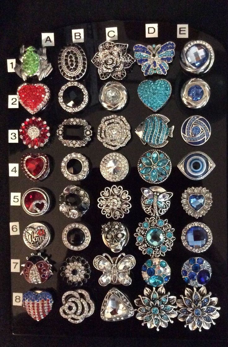 an assortment of brooches are displayed in a black box with numbers on it