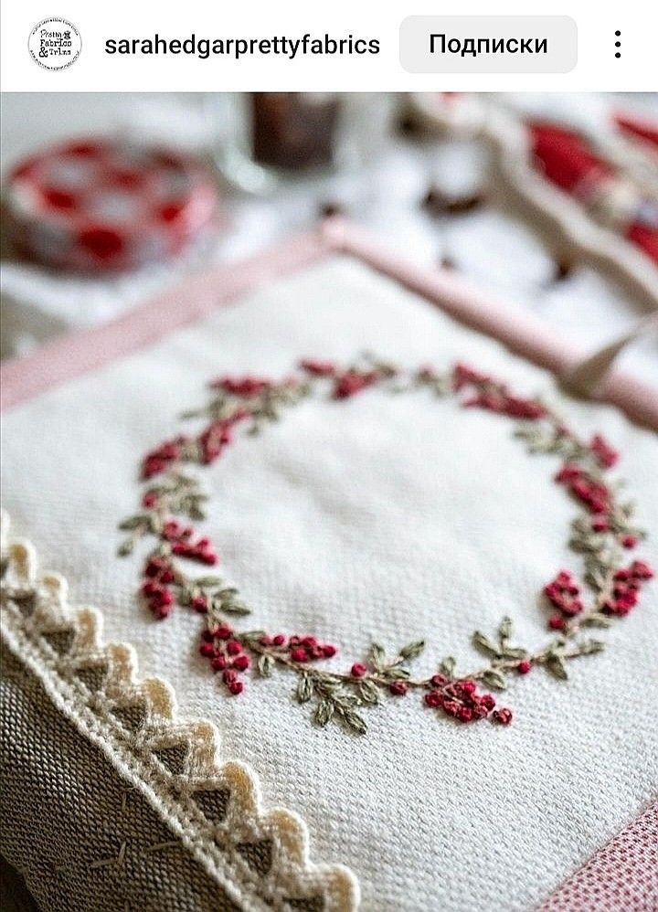 a close up of a piece of cloth on a table with a cross stitch pattern