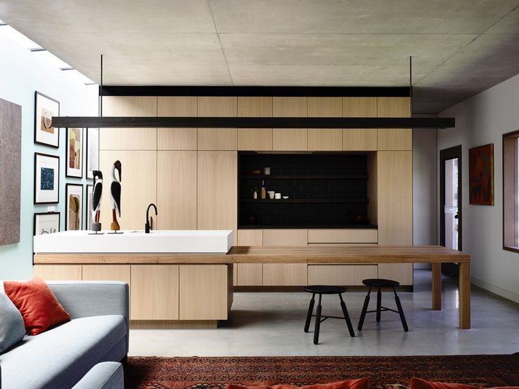 a living room filled with furniture next to a kitchen and dining room table on top of a rug