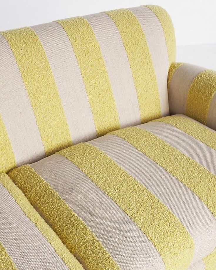 a yellow and white striped couch sitting on top of a floor