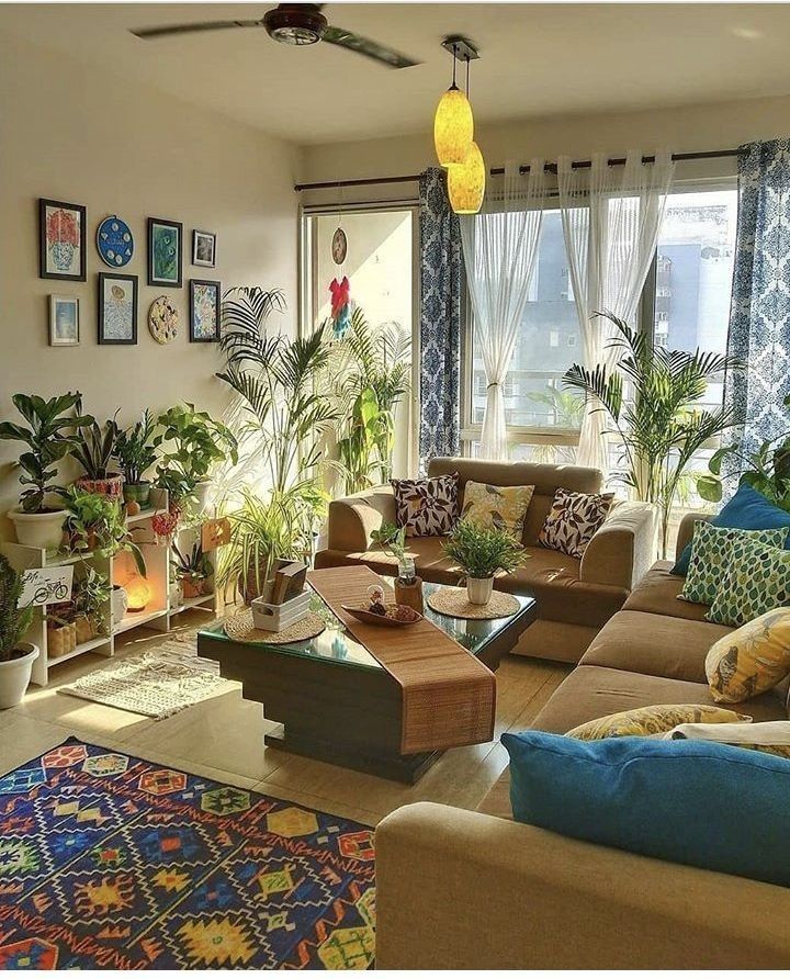 a living room filled with lots of furniture and plants