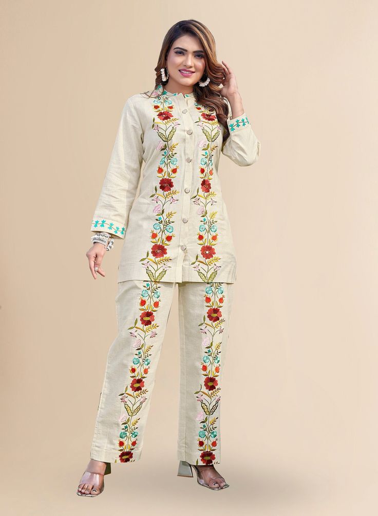 Reacquaint our elegant Beige suit set with exquisite floral embroidery, perfect for any occasion. Crafted from high-quality linen fabric, this suit offers a comfortable and breathable fit. The regular sleeves and mandarin neck add a touch of sophistication, while the beautiful floral embroidery and button placket at the front enhance its overall charm. The pants feature a partial elasticated waist for a customized fit and are adorned with floral embroidery. Additionally, the pants are equipped w Elegant Fitted Sets With Multicolor Embroidery, Traditional Spring Kurta With Set-in Sleeves, Fitted Floral Embroidery Sets With Stand Collar, Fitted Sets With Floral Embroidery And Stand Collar, Elegant Floral Embroidery Sets For Summer, Elegant Floral Embroidered Summer Sets, Elegant Floral Embroidered Sets For Summer, Elegant Summer Sets With Floral Embroidery, Elegant Embroidered Summer Pant Set