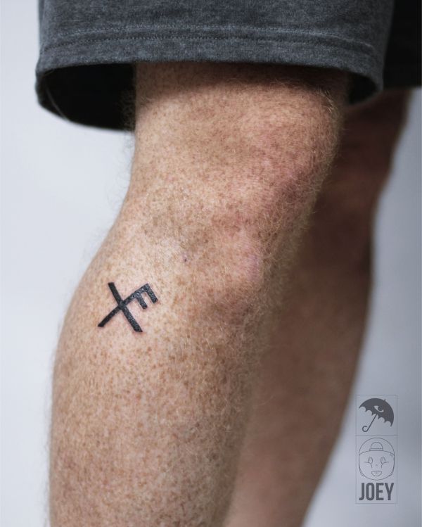 a man with a cross tattoo on his leg