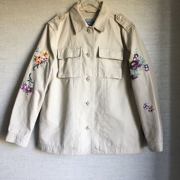 A Floral Embroidered Jacket Is The Next Addition To Your Outerwear Collection With Multiple Pockets And Front Button Closure. - Point Collar - Front Button Closure - Long Sleeves With Floral Embroidery Details - 2 Front Chest Flap Pockets - 2 Side Pockets - Solid - Approx. 28" Length 100% Cotton Machine Wash Cold Nwot Fall Beige Outerwear With Floral Embroidery, Beige Floral Embroidered Outerwear For Fall, Casual Cotton Outerwear With Embroidered Cuffs, Spring Cotton Outerwear With Embroidered Cuffs, Beige Cotton Outerwear With Floral Embroidery, Embroidered Cotton Button-up Outerwear, Embroidered Collared Outerwear For Winter, Beige Long Sleeve Outerwear With Floral Embroidery, Floral Embroidered Cotton Button-up Outerwear