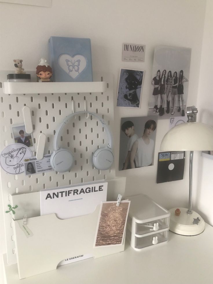 a white desk topped with lots of clutter and pictures next to a wall mounted clock