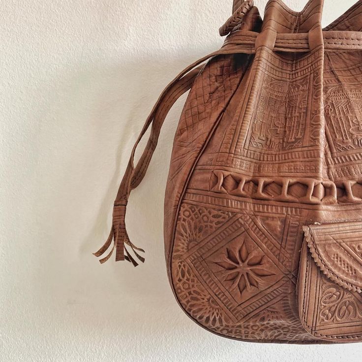 An amazing tan leather boho bag is the best addition to your bohemians bags collection.A stunning piece from our dazzling collection of authentic and stylish Leather crossbody hippie bags crafted in Marrakesh. Handmade and carved, functional, and perfect for office or weekends .Leather with a Boho pattern enhances the rich textural quality of a small bohemian bag crafted from soft leather . - 100% leather- 100% handmade- Long durabilityDimensions : 36 × 34 × 10 cm (H * L * W) Quality : We Wouldn Handmade Leather Shoulder Bag, Bohemian Bag, Leather Duffel Bag, Kilim Bag, Leather Duffel, Bohemian Bags, Hippie Bags, Shoulder Bag Brown, Genuine Leather Totes