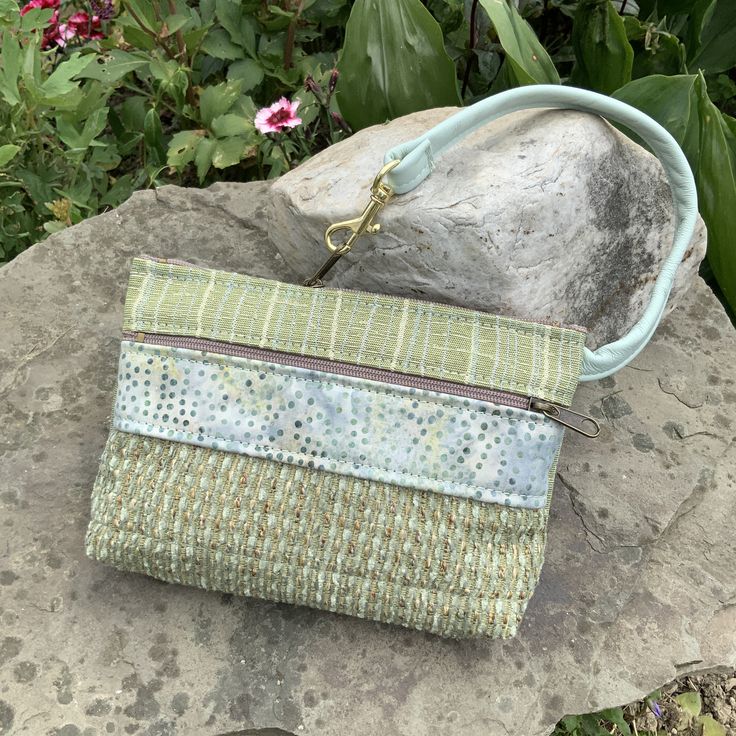 "Fresh Summer Color Mint Green Wristlet. Leather Strap,mixed with Batik and Industrial Quality Upholstery Fabric. The Front Pocket Fabric looks Handwoven! Large front zip pocket. Top zip opens to roomy interior. There's one inside pocket big enough for your credit cards. AND there's a clip off key ring It fits the largest phone. 7.5\" wide 4.75\" deep 1.25 bottom Use as your only bag, or use like a wallet and carry in a bigger bag. Great for an Evening bag , or when you want to carry only what y Green Rectangular Cosmetic Bag For On-the-go, Green Rectangular Pouch For On-the-go, Coin Purse Clutch With Wrist Strap, Clutch Bags With Wrist Strap As Gifts, Everyday Clutch Pouch With Wrist Strap, Green Rectangular Cosmetic Bag For Travel, Green Tote Pouch For Everyday Use, Rectangular Coin Purse With Cell Phone Pocket, Versatile Bags With Wrist Strap For On-the-go