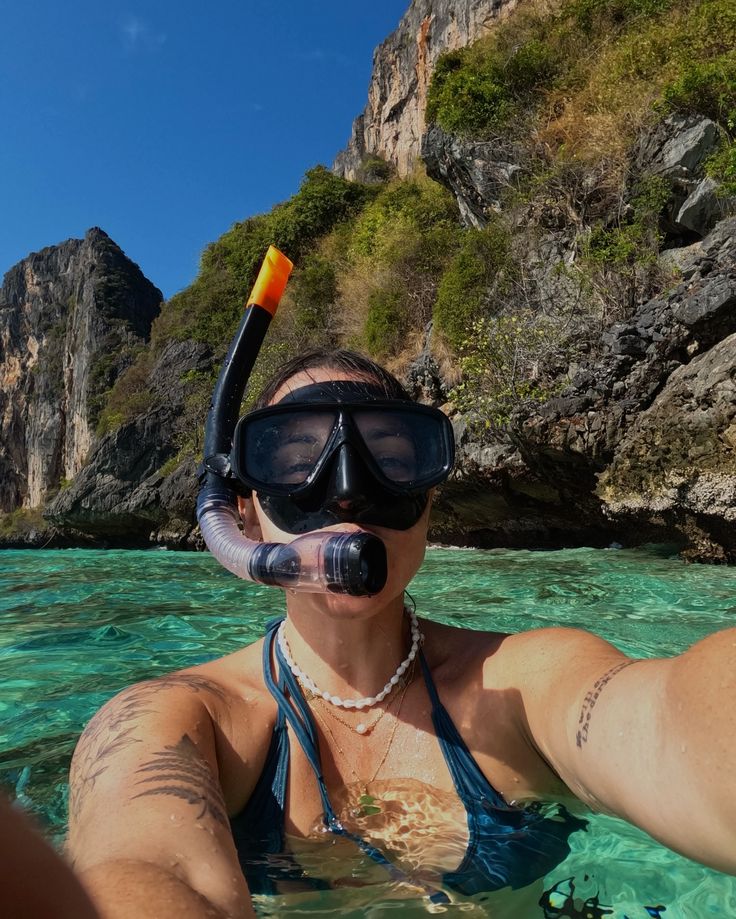 a woman in the water wearing a diving mask and snorkels