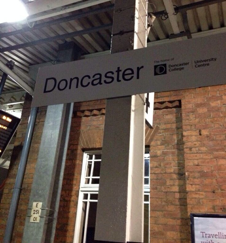 there is a sign that says donacaster on the side of a building in front of a brick wall