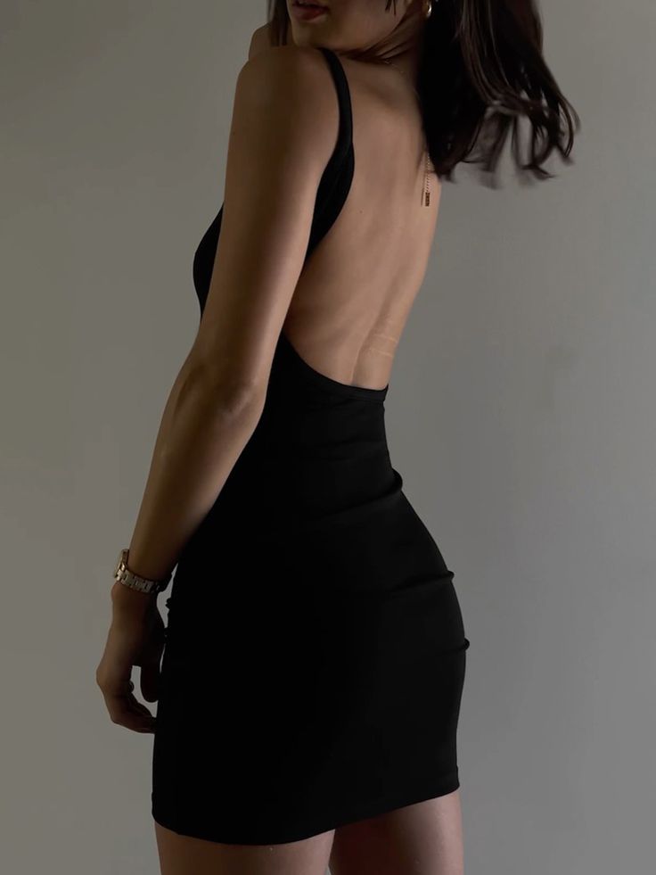 a woman in a short black dress with her back to the camera