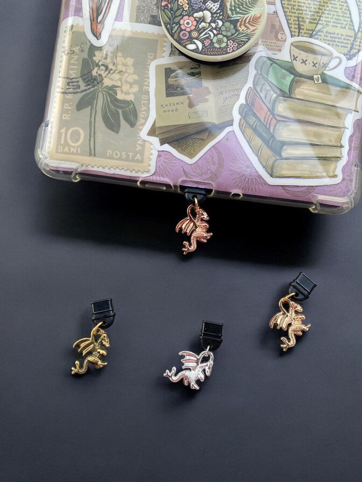 four small charms sitting next to each other on top of a black table with books