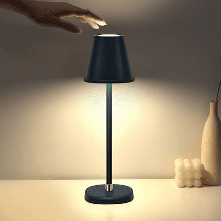 a hand reaching for something on a lamp