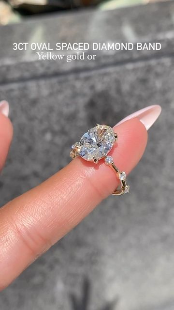 a woman's hand holding a diamond ring with the words, 3ct oval spaced diamond