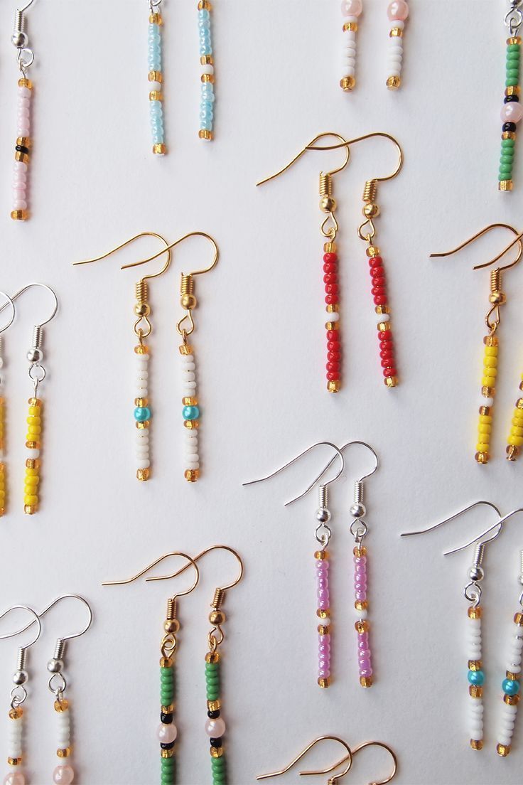 many different colored beads are hanging from earrings