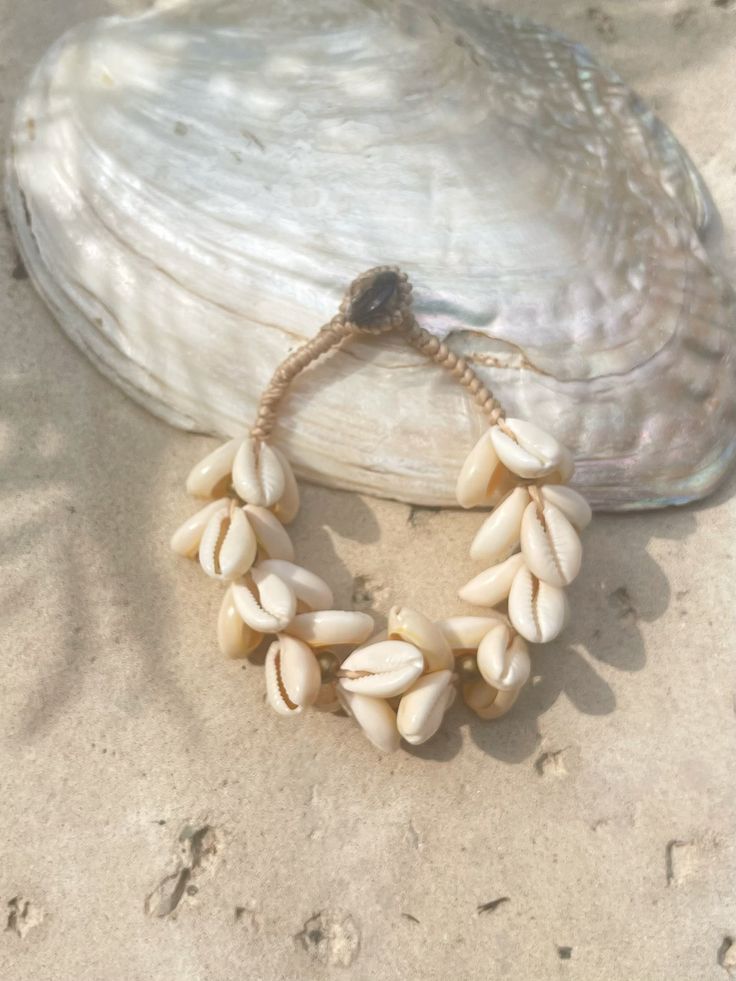 Introducing our new beach accessory: the OCEAN COWRIE SEASHELL BRACELET. Crafted with natural shells sourced from the depths of the ocean in Thailand, this statement piece beautifully captures the essence of the sea. Each shell is carefully combined to create a captivating and unique representation of oceanic beauty. Perfect for beach outfits, honeymoons, resort wear, or gift for your love ones, this choker necklace is a versatile addition to your wardrobe. What sets it apart is our commitment t Ocean-inspired Strand Jewelry For Beach Party, Coastal Beach Bracelet Jewelry, Shell Jewelry For The Beach In Coastal Style, Beachy Shell Bracelet Jewelry, Coastal Shell Jewelry For Beach Season, Coastal Shell Jewelry For Vacation, Bohemian Cowrie Shell Strand Bracelet, Shell Jewelry For Beach Season, Beach Season Shell Strand Jewelry