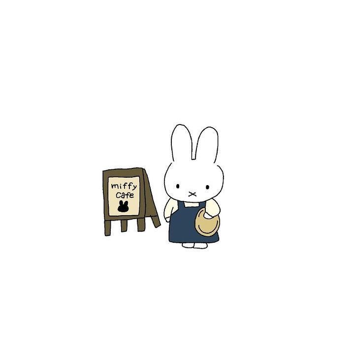 a white rabbit standing next to a sign