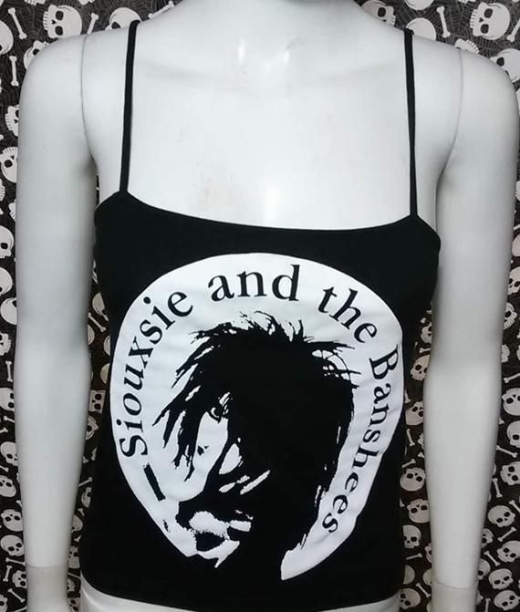 This is a black sleeveless Siouxsie and the Banshees cropped tank top.This has a Siouxsie image screen printed on the front. 95% cotton/ 5% SpandexThese are handmade screenprinted and slightly vary from the photo. Please feel free to email me any questions. Thanks for looking.Due to an influx of incorrect addresses if a package is returned,  you must pay the shipping cost to resend the item to you.I do not do exchanges and I do not take returns unless the item is damaged. I thoroughly check each Fitted Black Crop Top Band Merch, Fitted Alternative Style Tank Top With Graphic Print, Black Edgy Tank Crop Top, Fitted Black Emo Tank Top, Edgy Black Tank Crop Top, Fitted Black Emo Style Tank Top, Fitted Graphic Print Tank Top For Alternative Fashion, Black Band Merch Crop Top For Summer, Fitted Punk Tank Top With Graphic Print