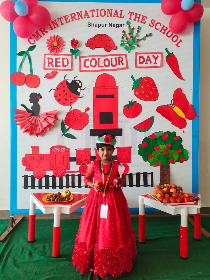 a woman standing in front of a red and white wall with lots of decorations on it