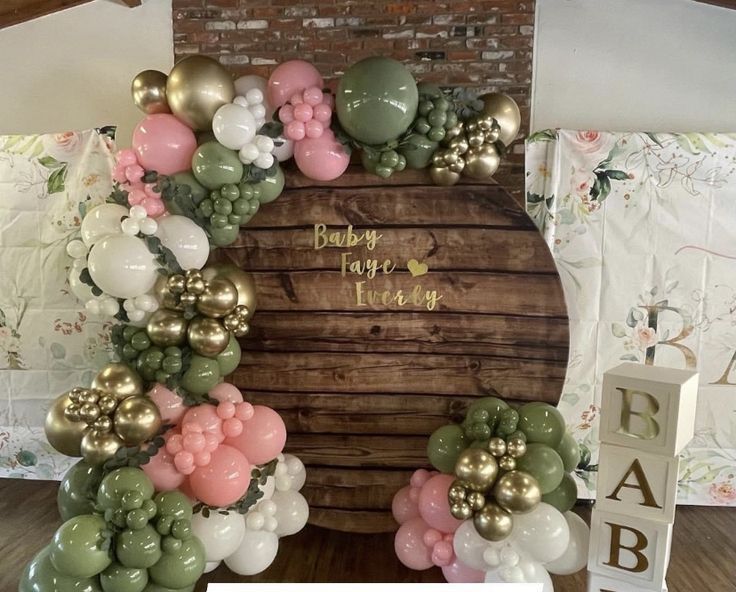 a baby's first birthday balloon arch with balloons and flowers on the front door