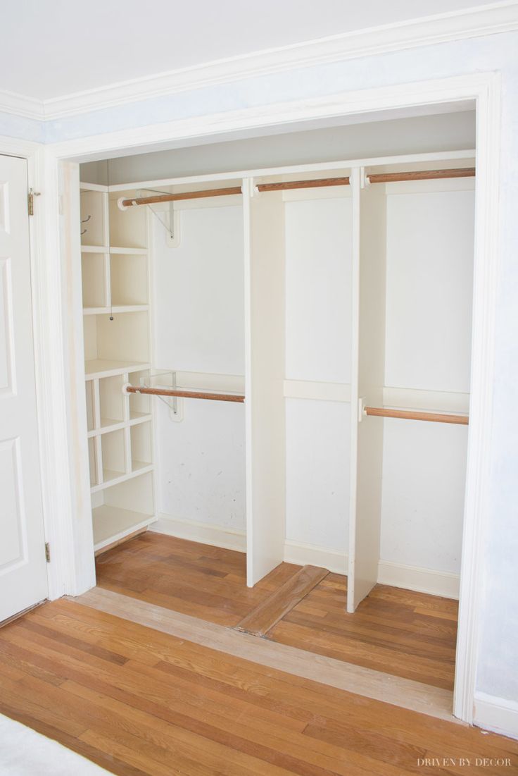 an empty closet with white walls and wooden floors