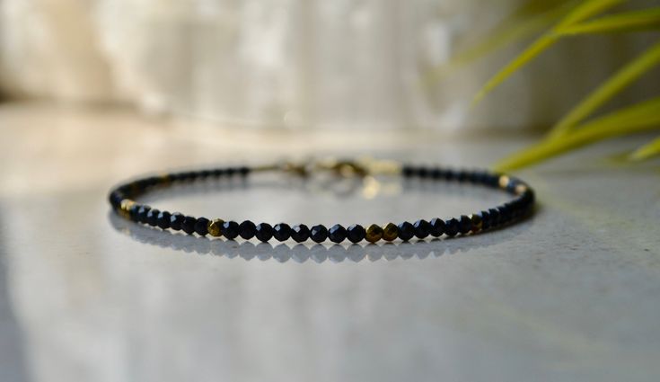 "Tiny black spinel beaded gemstone bracelet with hematite gold beads and gold vermeil claps, bracelet femme is a perfect bridesmaid gift or anniversary present. . ❗️Sign up to our Newsletter and get 15% OFF your order (copy this link to browser search) - https://forms.gle/R74xLdL1MSmC9Apn6 ❗️ . Price is for ONE bracelet ONLY. . MEASUREMENTS: Beads: Black Spinel 2 mm; gold-plated hematite - 2 mm Clasp: Gold vermeil (gold plated 925 sterling silver) Length: You can choose the length of the bracele Unique Beaded Bracelet, Garnet Bracelet, Etsy Bridesmaid Gifts, Quartz Bracelet, Jewelry Bracelet, Gemstone Bracelets, Dainty Jewelry, Gemstone Bracelet, Bridesmaid Gift