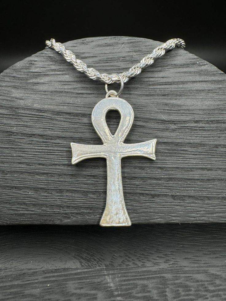 Embrace the timeless symbolism of the Ankh with our versatile jewelry set, featuring both a pendant and fish hook earrings available in your choice of sterling silver or bronze. The Ankh, revered in ancient Egyptian culture, symbolizes life, vitality, and spiritual connection. Crafted with meticulous detail, each piece captures the essence of the Ankh's sacred significance. Whether you opt for the classic elegance of sterling silver or the warm radiance of bronze, this set offers a meaningful expression of ancient wisdom. Wear the pendant close to your heart or adorn your ears with the matching fish hook earrings--each piece resonates with the power of the Ankh, inviting spiritual growth and renewal. This jewelry set is perfect for personal wear or as a thoughtful gift for those intrigued Traditional Adjustable Cross Jewelry, Spiritual Ankh Shaped Metal Jewelry, Symbolic Bronze Jewelry, Spiritual Silver Etched Jewelry, Silver Etched Cross Pendant Jewelry, Silver Ankh Symbolic Necklace, Sterling Silver Ankh Amulet Jewelry, Symbolic Ankh Shaped Metal Jewelry, Spiritual Antique Silver Nickel-free Jewelry