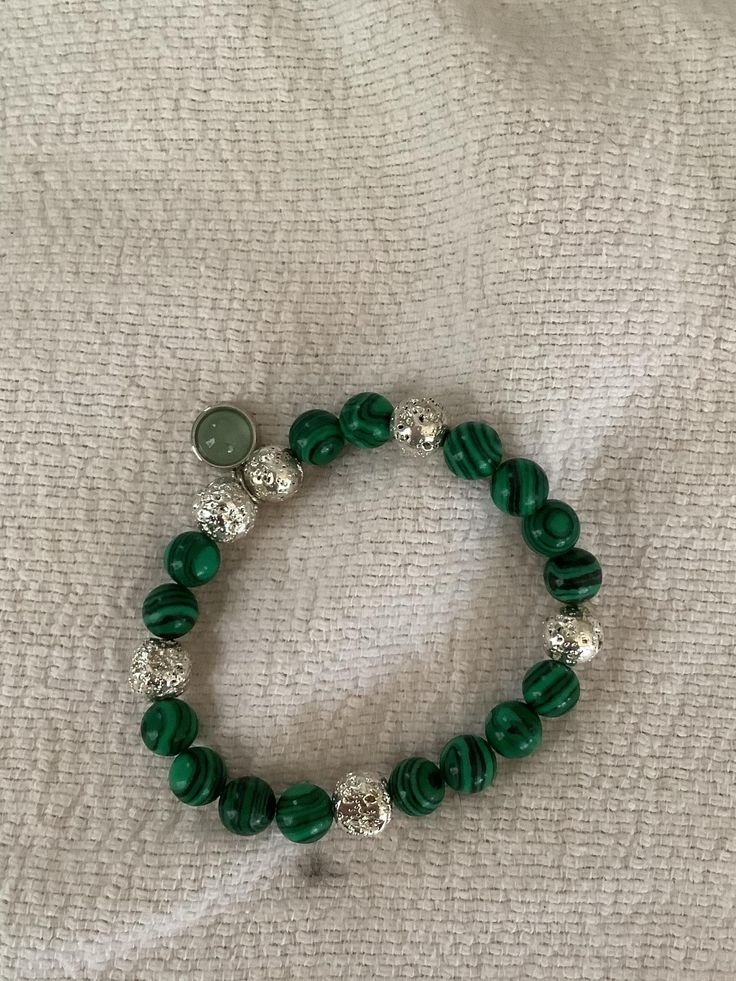 Malachite beads with silver accents and an adventurine charm. Green Malachite Beaded Bracelets, Malachite Beaded Bracelets With Round Beads, Malachite Beaded Bracelets With Round Natural Stones, Green Malachite Spiritual Beaded Bracelets, Spiritual Green Malachite Beaded Bracelets, Malachite Beaded Bracelets As Gift, Malachite Beaded Bracelet As A Gift, Spiritual Malachite Beaded Bracelets With Gemstone Beads, Green Beads With Silver Details For Gifts