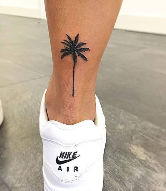 a small palm tree tattoo on the ankle