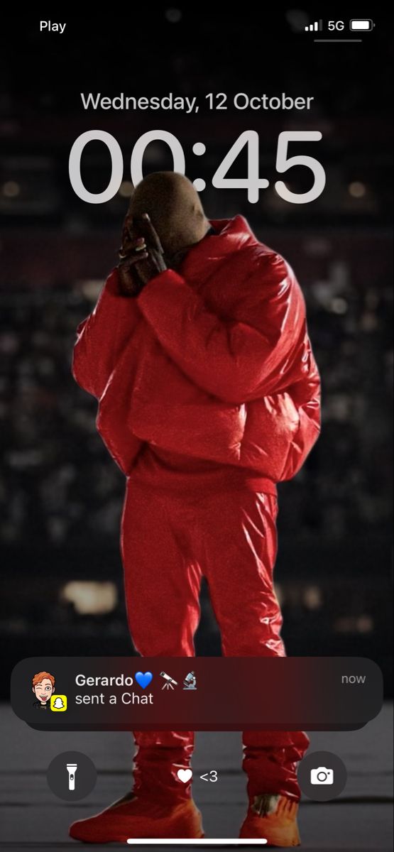 an image of a man in red on his cell phone with the date and time displayed