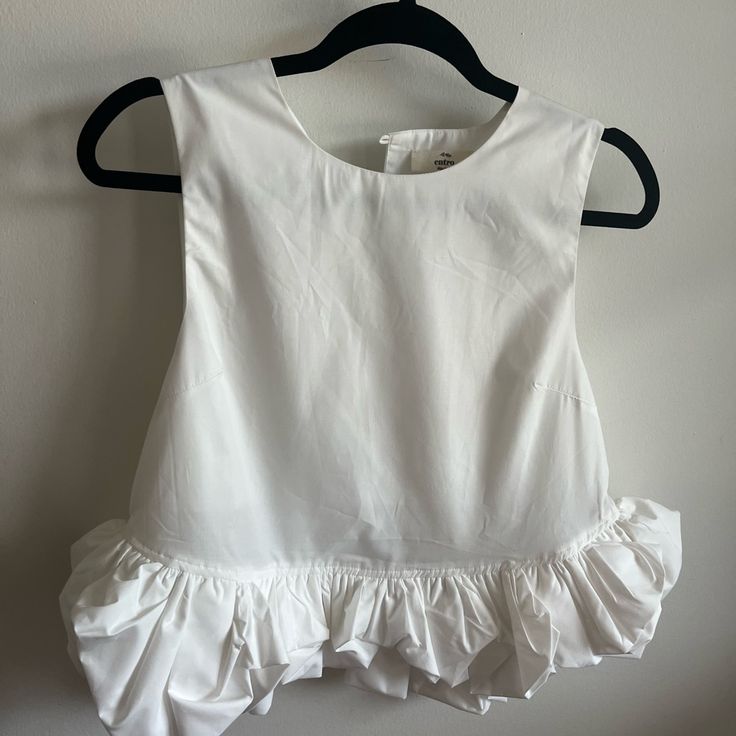 Sleeveless Ruffle Hem Top With Button Closure On Back New With Tags White Chic Sleeveless Crop Top, Spring Chic Crop Top With Ruffle Hem, Chic Spring Crop Top With Ruffle Hem, Elegant Sleeveless Crop Top For Day Out, Elegant Tank Crop Top For Spring, Elegant Spring Tank Crop Top, Feminine Sleeveless Ruffle Crop Top, Feminine Sleeveless Ruffled Crop Top, Cropped Ruffled Blouse For Day Out