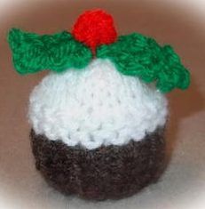 a small knitted cupcake with a red cherry on top