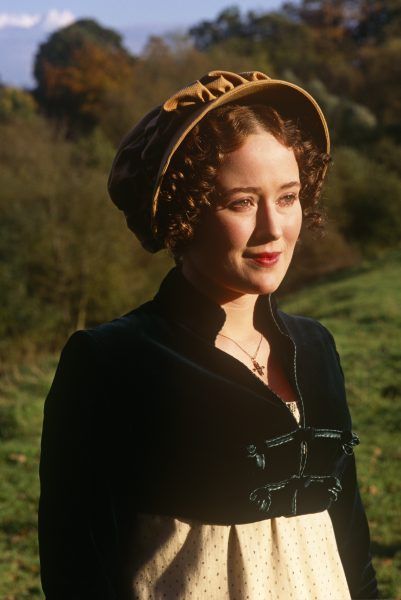 a woman wearing a hat and dress in a field