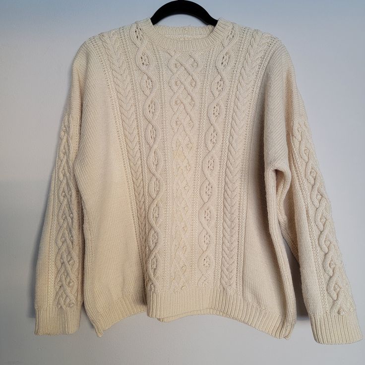 "Excellent Vintage Condition Women's Handknit Cable Knit Pullover Sweater with Fisherman's Rib Hem Cream color or off-white Yarn feels like wool or wool blend (heavy) No shrinkage (looks unworn), no visible stains (clean) No size indicated  Measurements are approximate (laying flat): Length: 23\" Shoulders: 27\" Chest (pit to pit): 24\" Hem: 42\" Sleeve length (shoulder to cuff): 16 1/2\" Arm hole (pit to pit): 19\"" Cream Crew Neck Cardigan, White Knitted Crew Neck Sweater, Beige Knitted Crew Neck Outerwear, Beige Knitted Crew Neck Sweater, Beige Knit Crew Neck Sweater, Winter White Knitted Long Sleeve Sweater, Beige Crew Neck Knitted Sweater, Beige Crew Neck Knit Sweater, Off White Long Sleeve Winter Cardigan