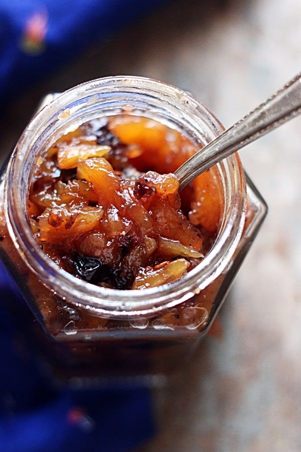 a glass jar filled with food sitting on top of a table next to a spoon