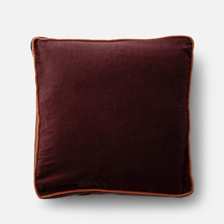 a dark brown pillow with an orange piping on the front and back side, against a white background