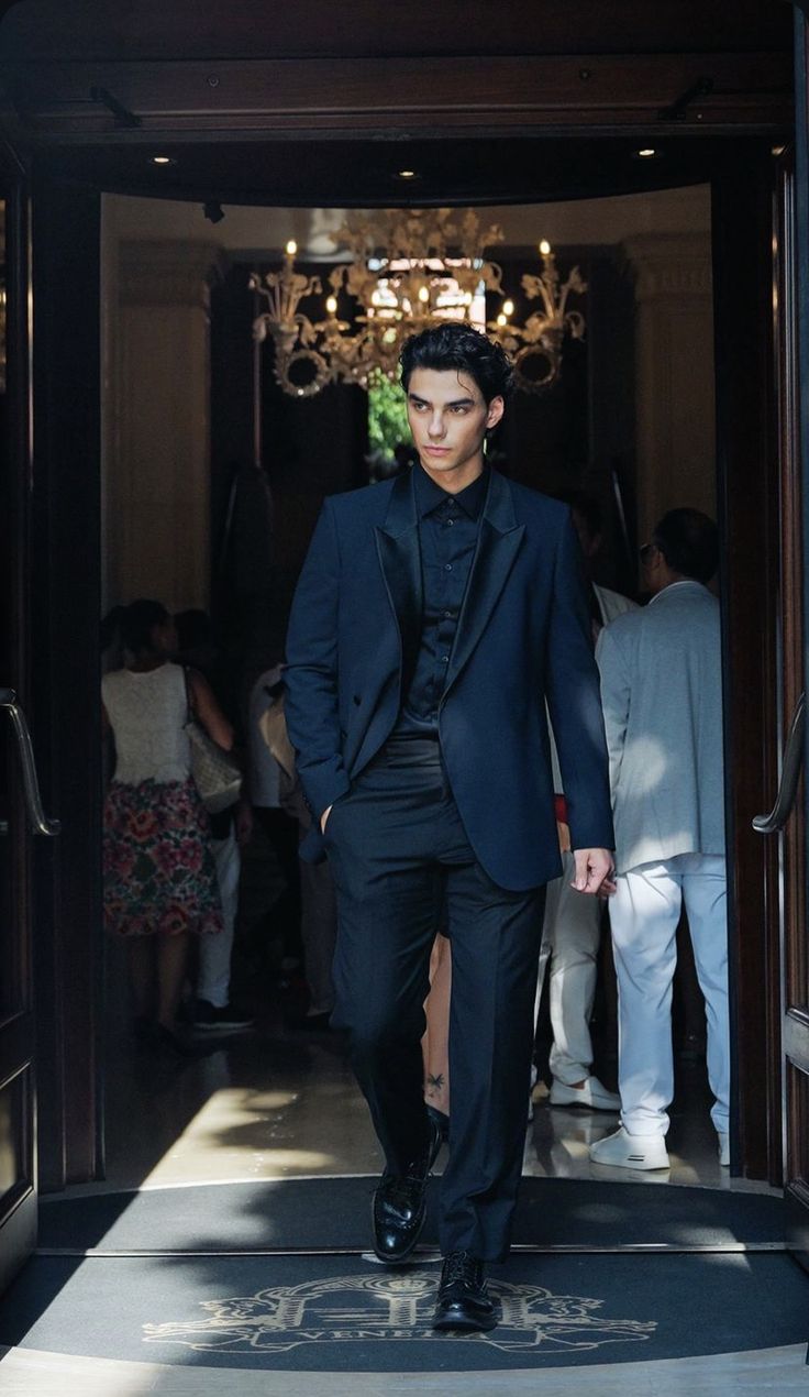 a man in a tuxedo walking into a doorway