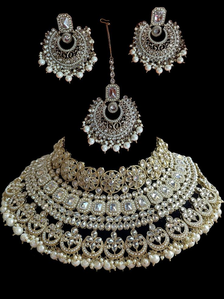 This bridal set comes in a gorgeous white beads and bronze gold plating. The set is lightweight and can easily be worn separately for a lighter and simple look. The finishing is done in gold and is completely handmade with intricate work. Only one piece in stock! Festive White Gold Plated Jewelry, Festive White Gold-plated Jewelry, Festive White Jewelry Sets With Elegant Design, Festive White Bridal Earrings With Elegant Design, White Bridal Earrings With Intricate Design For Festive Occasion, White Gold-plated Jewelry With Intricate Design, White Temple Jewelry Sets With Intricate Design, White Intricate Gold Plated Jewelry, Festive Hand Set White Pearl Necklace